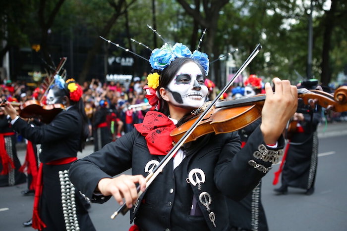 Una mujer toca el violín mientras participa en el desfile del Día de Muertos en la Ciudad de México, el sábado 29 de octubre de 2022.