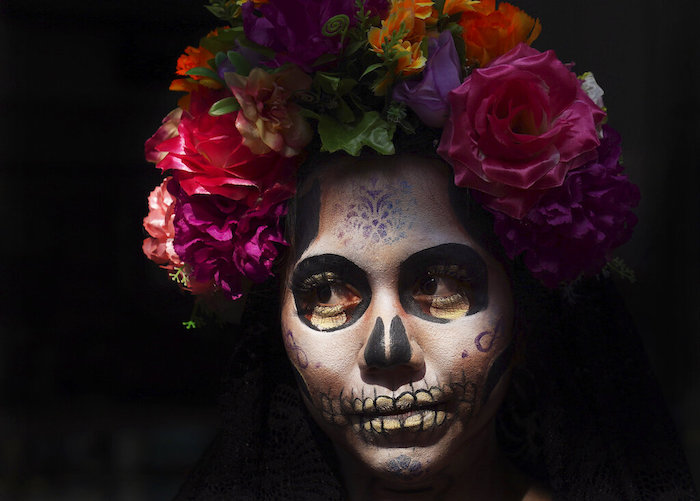 Una mujer vestida como la icónica "Catrina" de México posa para los turistas en la plaza principal de la Ciudad de México, el Zócalo, como parte de las festividades del Día de Muertos en la Ciudad de México, el viernes 28 de octubre de 2022.