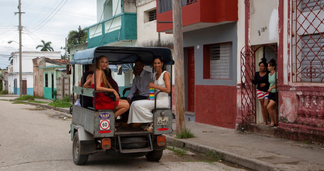 Las novias Lisset Díaz Vallejo, izquierda, y Liusba Grajales viajan en un taxi a la notaría para casarse en Santa Clara, Cuba, el viernes 21 de octubre de 2022.