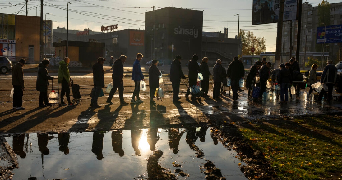 Unas personas se forman para llenar botellas de plástico con agua potable de un tanque en el centro de Mykolaiv, Ucrania, el lunes 24 de octubre de 2022.