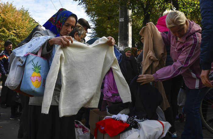 Varias personas revisan ropa de segunda mano en un centro de distribución de ayuda humanitaria el jueves 6 de octubre de 2022, en Slavyansk, en la región de Donetsk, Ucrania.