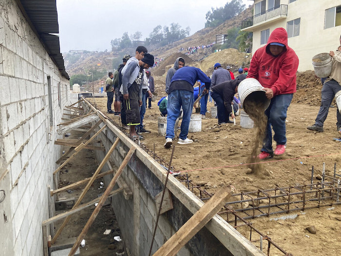 Voluntarios migrantes construyen un campo de futbol en el Templo Embajadores de Jesús, el mayor albergue de la ciudad fronteriza mexicana de Tijuana, el 13 de octubre de 2022.