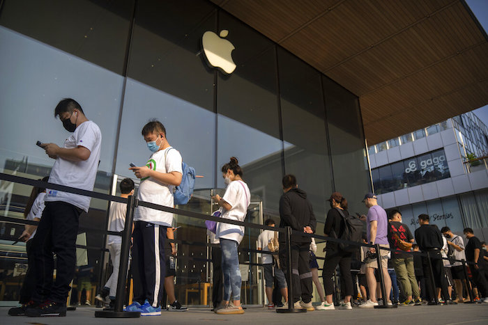 Clientes hacen fila fuera de una Apple Store antes de que abra para el primer día de ventas del iPhone 14, el 16 de septiembre de 2022, en Beijing.