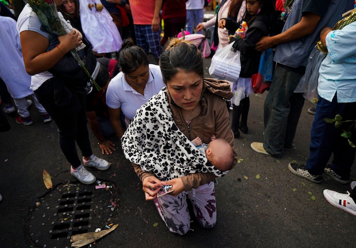 Devotas avanzan con dificultad sobre sus rodillas rumbo a altar de "La Santa Muerte", en el barrio de Tepito de la Ciudad de México, el martes 1 de noviembre de 2022.