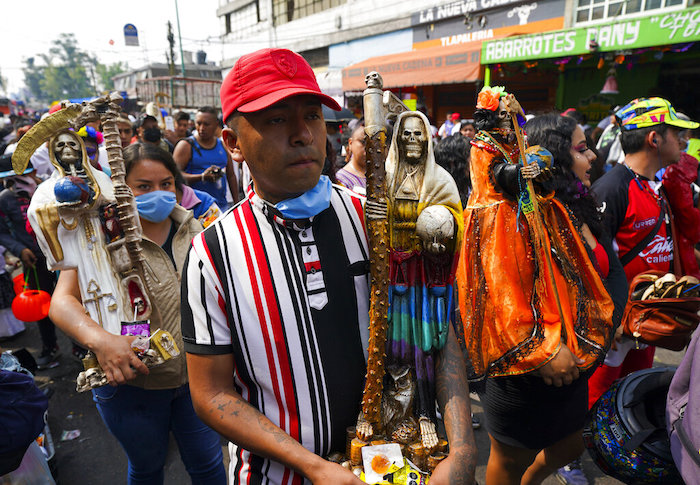 Devotos cargan estatuas ornamentadas de "La Santa Muerte", en el barrio de Tepito de la Ciudad de México, el martes 1 de noviembre de 2022. La Santa Muerte es una imagen de culto y un santo popular, una personificación de la muerte, asociada con la curación, la protección y la entrega segura al más allá por parte de sus devotos.