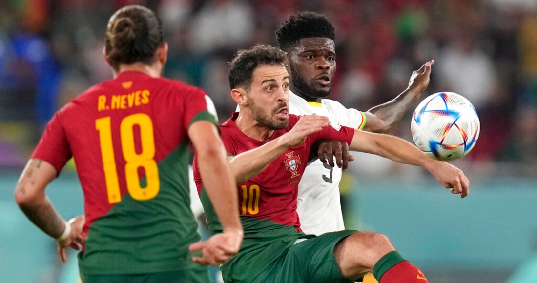 El portugués Ruben Neves (izquierda) observa al ghanés Thomas Partey (derecha) pugnando el balón con el portugués Bernardo Silva en el partido por el Grupo H del Mundial, el jueves 24 de noviembre de 2022.