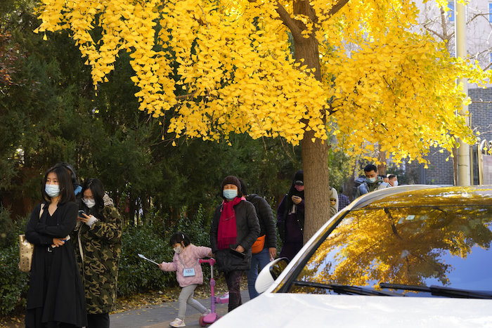 Gente con mascarillas hace fila para pruebas de COVID-19 en Beijing, el martes 15 de noviembre de 2022.