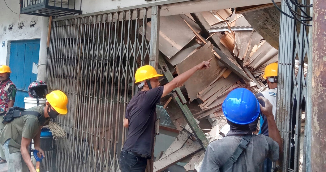 Trabajadores inspeccionan una tienda dañada durante un sismo en Cianjur, Java Occidental Indonesia, el lunes 21 de noviembre de 2022.