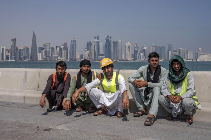 En esta imagen de archivo, trabajadores migrantes paquistaníes posan para una fotografía durante un descanso en su jornada laboral, en el paseo marítimo, con vistas al perfil de la ciudad de Doha, en Qatar, el 19 de octubre de 2022.