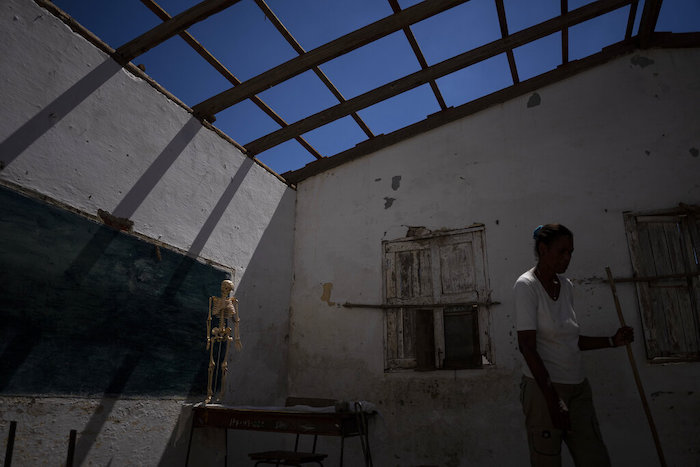 Un voluntario limpia un aula sin techo en una escuela gravemente dañada por el huracán "Ian" en La Coloma, en la provincia de Pinar del Río, Cuba, el miércoles 5 de octubre de 2022. 