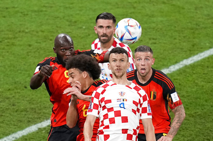 El croata Ivan Perisic (4) salta por el balón en medio de los belgas Romelu Lukaku (izquierda), Axel Witsel (abajo izquierda) y Toby Alderweireld (derecha) en el partido por el Grupo F del Mundial, el jueves 1 de diciembre de 2022. El croata Marko Livaja mira al fondo.