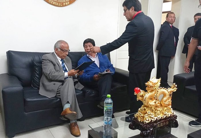 En esta foto proporcionada por la Oficina de Administración de la policía de Perú, el expresidente Pedro Castillo, segundo desde la izquierda, y el exprimer Ministro Aníbal Torres, en el extremo izquierdo, se sientan mientras el fiscal Marco Huaman se encuentra en el centro dentro de una estación de policía en Lima, Perú, el miércoles 7 de diciembre de 2022.