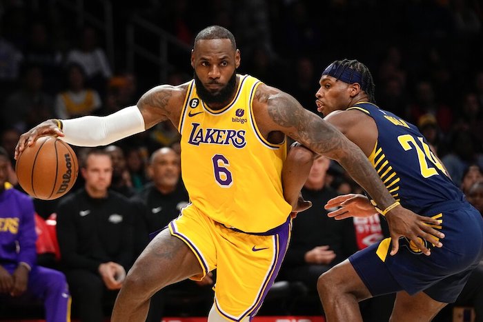 El jugador de Los Lakers de Los Ángeles LeBron James, a la izquierda, avanza junto al jugador de los Pacers de Indiana Buddy Hield durante la primera mitad de su juego de NBA el lunes 28 de noviembre de 2022 en Los Ángeles.