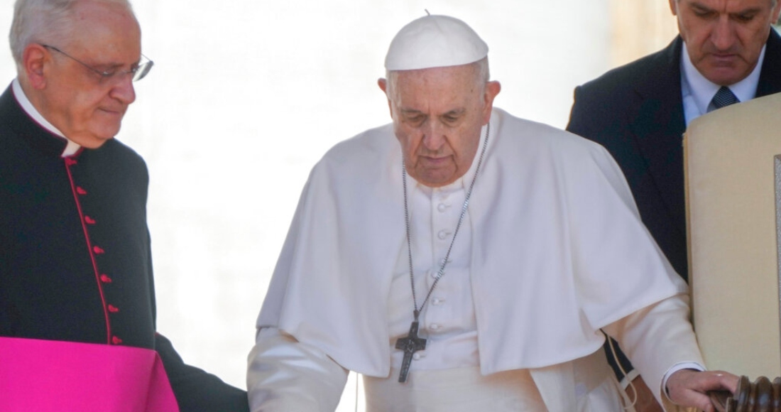 El Papa Francisco recibe ayuda del monseñor Leonardo Sapienza, a la izquierda, mientras camina con un bastón a su audiencia general en la Plaza de San Pedro del Vaticano, el 1 de junio de 2022.