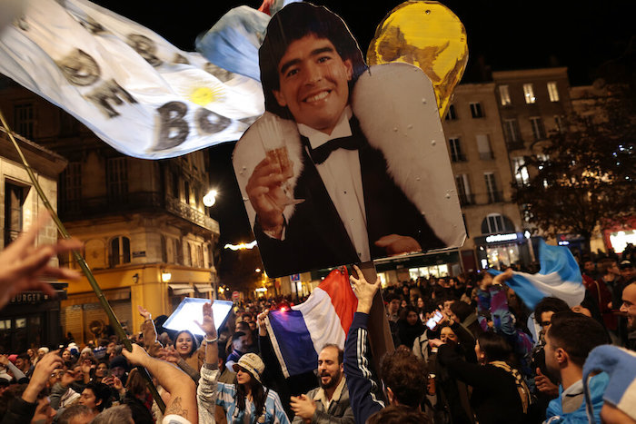 Hinchas argentinos alzan una imagen de Diego Maradona en Burdeos, Francia, mientras presencian la final de la Copa del Mundo, el domingo 18 de diciembre de 2022.