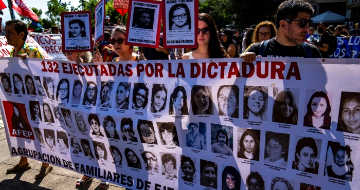 Manifestantes muestran una pancarta con retratos de mujeres asesinadas durante la dictadura militar de Augusto Pinochet, durante una marcha con motivo del Día de los Derechos Humanos, realizada en Santiago, Chile, el sábado 10 de diciembre de 2022.