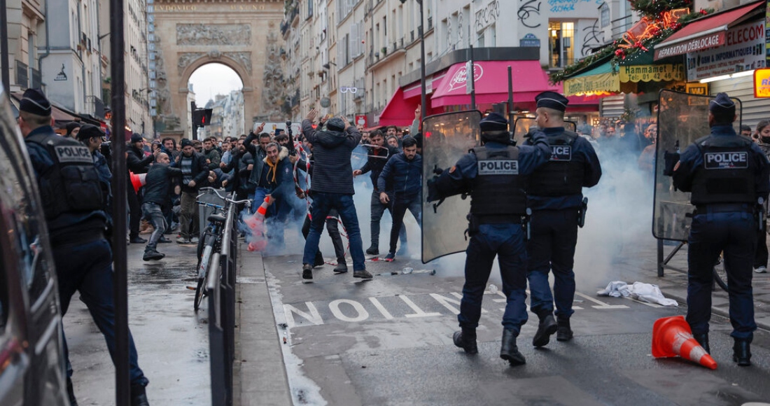 Miembros de la comunidad kurda se enfrentan con policías luego de un tiroteo en París, el viernes 23 de diciembre de 2022.