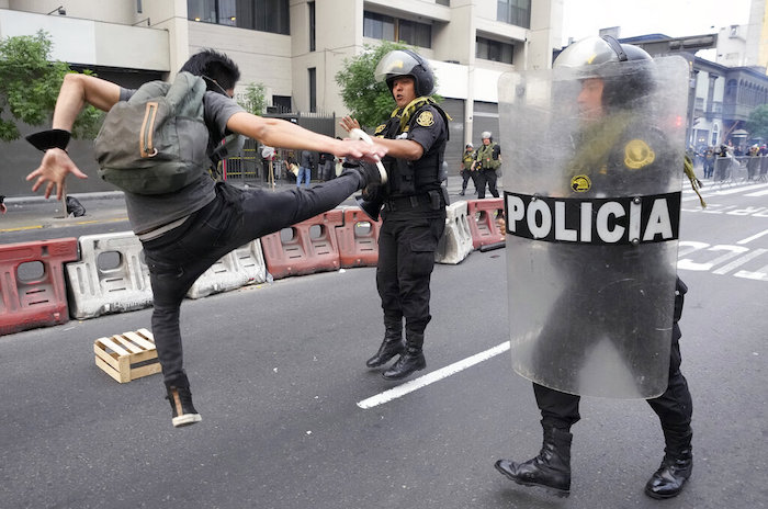 Un seguidor del destituido Presidente Pedro Castillo golpea de una patada en el aire a un agente de la policía en una protesta en Lima, Perú, el jueves 8 de diciembre de 2022.