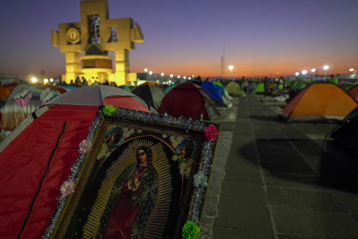 Una imagen de la Virgen de Guadalupe se encuentra en medio de los peregrinos que acampan frente a la Basílica de Guadalupe en la Ciudad de México, la madrugada del lunes 12 de diciembre de 2022.