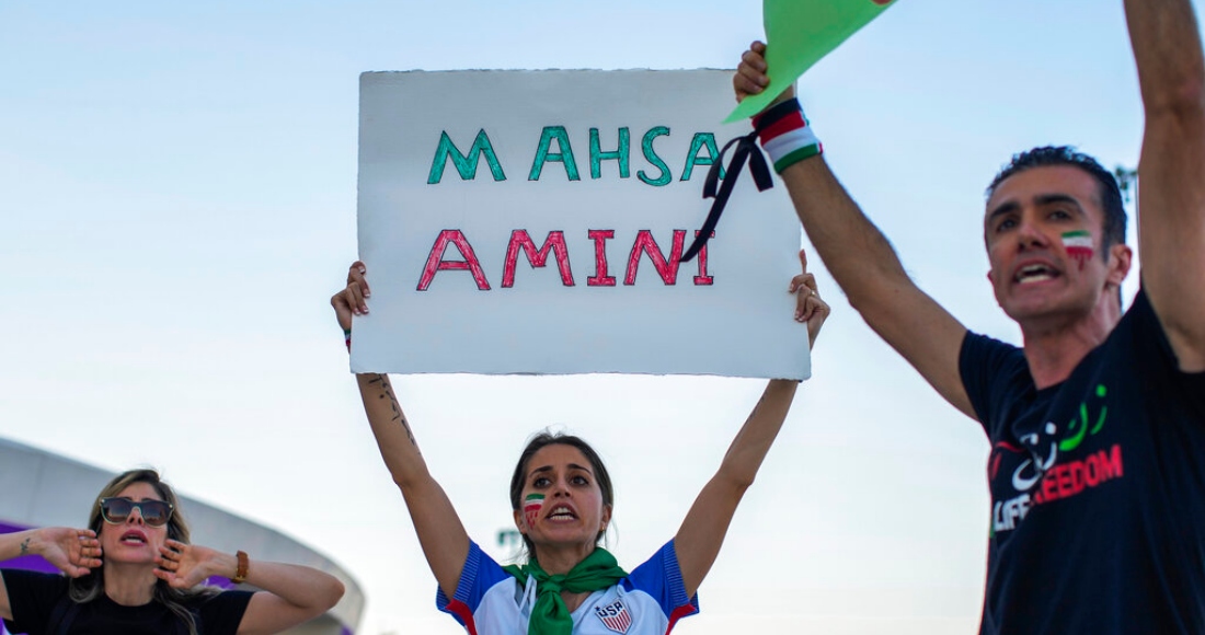 Una mujer sostiene un cartel con el nombre de Mahsa Amini, una mujer que murió mientras estaba detenida por la policía en Irán, durante una protesta después del un partido del Grupo B del Mundial entre Gales e Irán, en el estadio Ahmad Bin Ali en Rayán, Qatar, el 25 de noviembre de 2022.