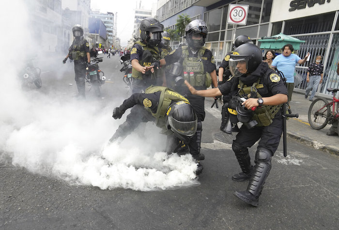 Agentes de policía recogen una lata de gas lacrimógeno que les fue arrojada por manifestantes antigubernamentales llegados desde todo el país para protestar contra la Presidenta, Dina Boluarte, en Lima, Perú, el 18 de enero de 2023.