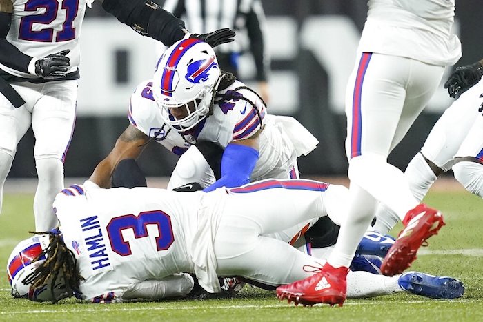 Damar Hamlin, safety de los Bills de Buffalo, cae al terreno tras derribar a Tee Higgins, receptor de los Bengals de Cincinnati, en el partido del lunes 2 de enero de 2023.