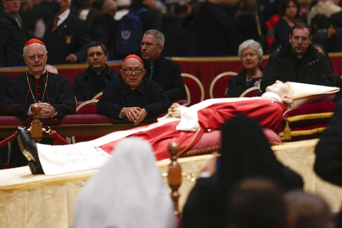 El cardenal Odilo Scherer (izquierda) reza frente al cuerpo del Papa emérito Benedicto XVI en la Basílica de San Pedro, en el Vaticano, el martes 3 de enero de 2023.