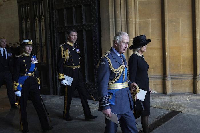 El rey Carlos III de Gran Bretaña (segundo desde la derecha), la reina consorte Camilla (derecha) y la princesa Ana (izquierda) caminan después de presentar sus respetos ante el cuerpo de la reina Isabel II en el Salón Westminster en Londres, el 14 de septiembre de 2022.