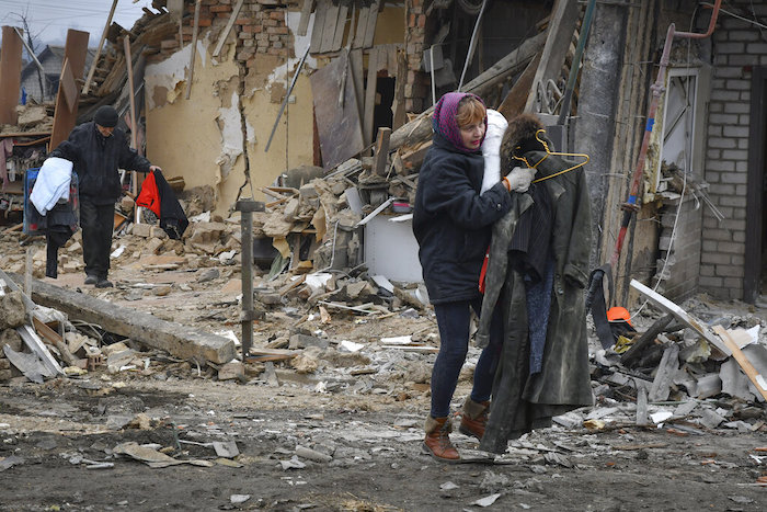 Habitantes locales cargan sus pertenencias al salir de sus casas en Zaporiyia, Ucrania, el domingo 1 de enero de 2023.