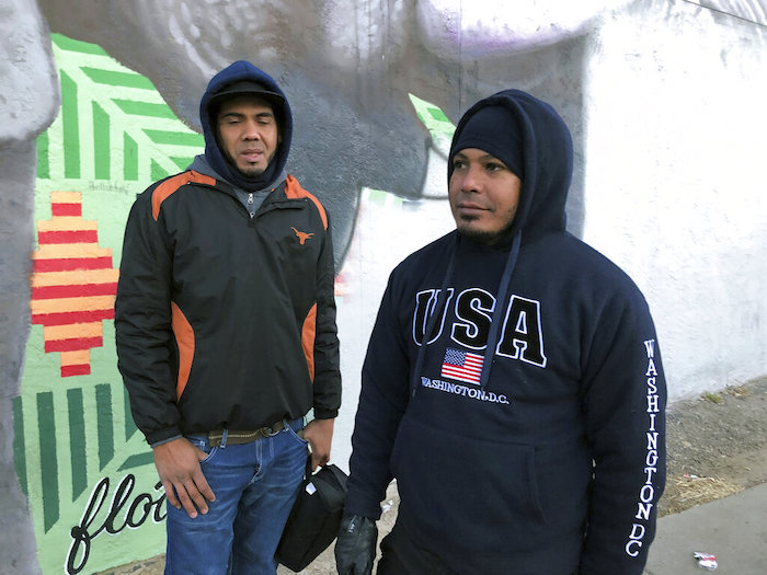 Los migrantes venezolanos Abraham Guedez (izquierda) y Javier Guillén frente a una estación de autobuses en Denver el viernes 6 de enero de 2023.