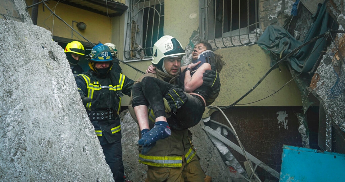 En esta imagen publicada el 16 de enero de 2023 por el Servicio Estatal de Emergencias de Ucrania, un bombero lleva a una mujer herida fuera de los escombros de un edificio tras un ataque ruso el sábado en Dnipro, Ucrania, el domingo 15 de enero de 2023.