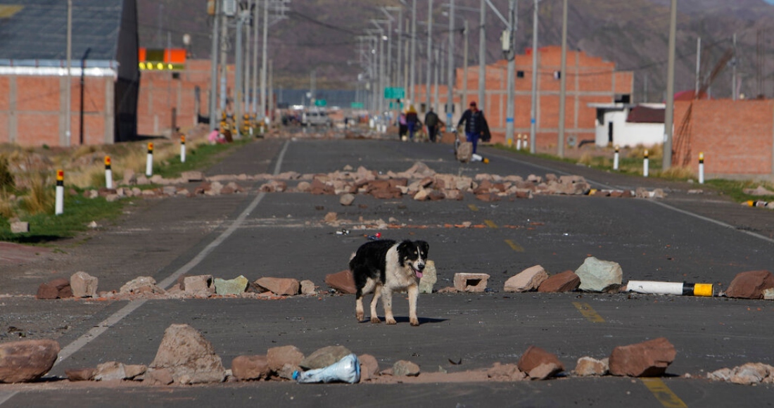 Un perro pasa frente a los bloqueos de carreteras establecidos por manifestantes antigubernamentales en Desaguadero, Perú, en la frontera con Bolivia, el viernes 13 de enero de 2023.