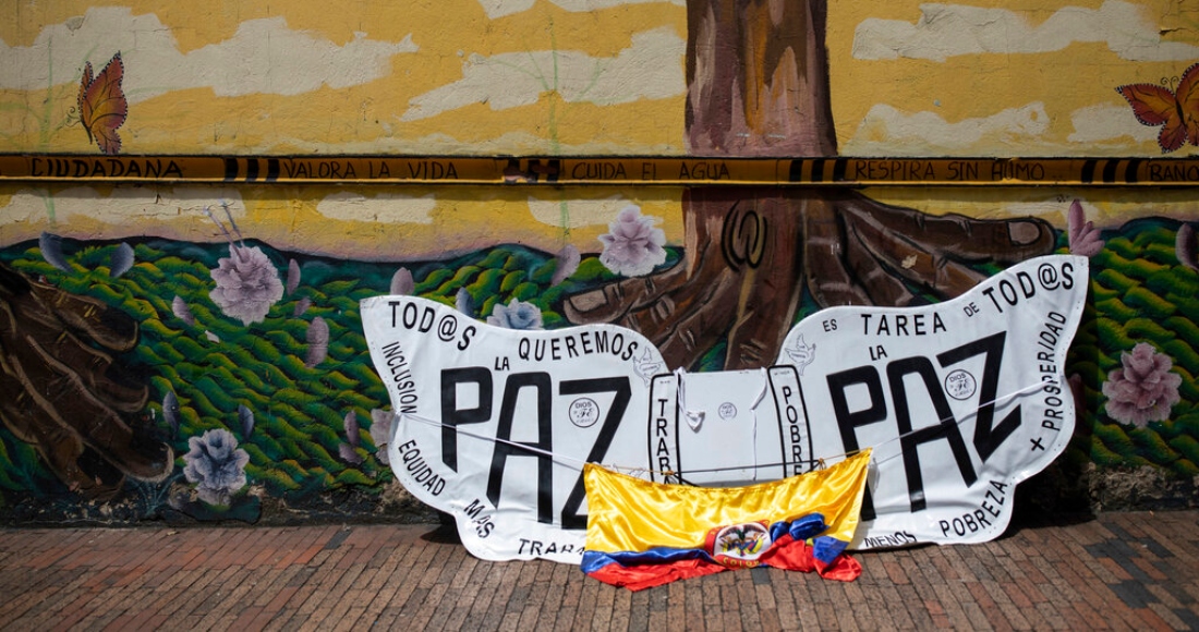 Una bandera de Colombia y alas esculpidas con mensajes que piden la paz se apoyan contra una pared durante una marcha contra la reforma fiscal y otras iniciativas del Gobierno del Presidente Gustavo Petro en el centro de Bogotá, Colombia, el 26 de septiembre de 2022.