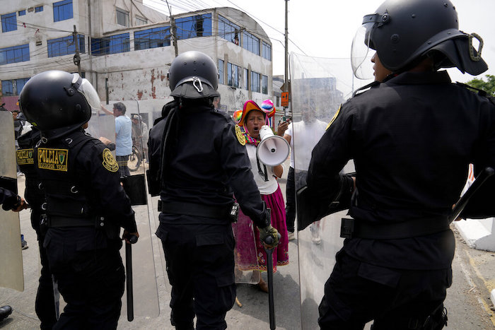 Una manifestante antigubernamental desafía a la policía que rodea la Universidad de San Marcos en Lima, Perú, el sábado 21 de enero de 2023.