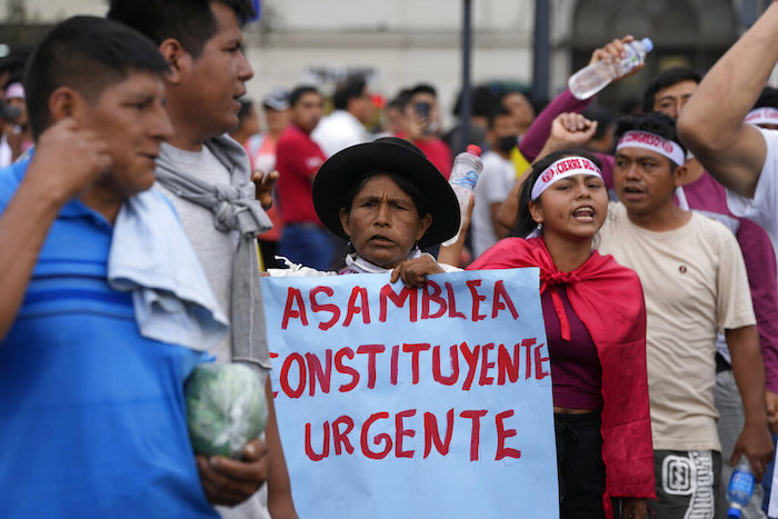 Una mujer sostiene un cartel que pide convocar a una asamblea constituyente durante una marcha de manifestantes de oposición que viajaron a la capital desde otras partes del país, contra la Presidenta peruana Dina Boluarte en Lima, Perú, el miércoles 18 de enero de 2023.