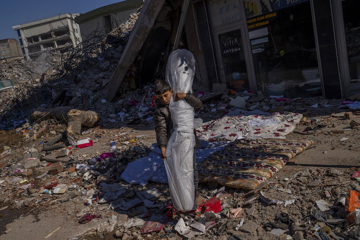 El hijo de la familia Sonmez recupera una alfombra de la vivienda tras el potente sismo que golpeó Kahramanmaras, Turquía, el 17 de febrero de 2023.