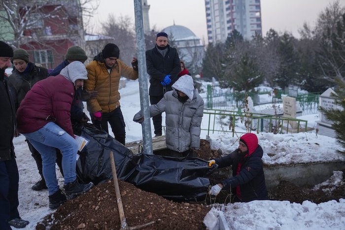 Familiares y amigos de la refugiada siria Naziha Al-Ahmad la entierran en un cementerio después que murió a causa del terremoto, en Elbistan, Turquía, el viernes 10 de febrero de 2023.