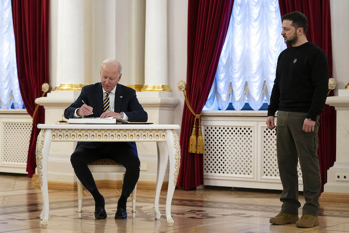 El Presidente ucraniano Volodímir Zelenski observa mientras el mandatario estadounidense Joe Biden firma el libro de visitantes en el Palacio Mariinsky, en Kiev, el lunes 20 de febrero de 2023.