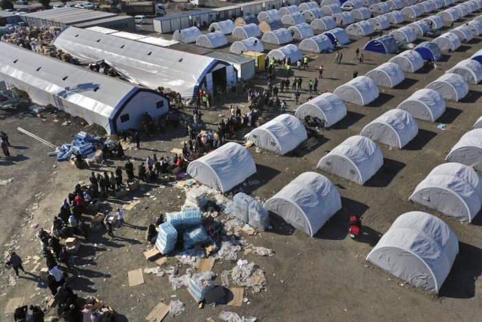 Personas que perdieron sus viviendas por un sismo devastador hacen fila para recibir víveres en un campamento improvisado, en Alejandreta, en el sur de Turquía, el 14 de febrero de 2023.