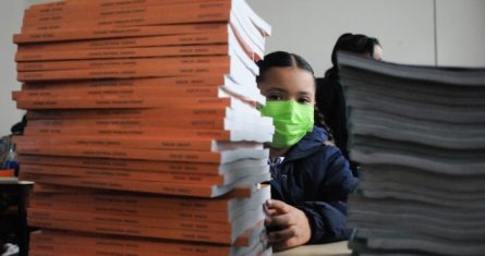 Una niña con libros de texto en su regreso a clases.