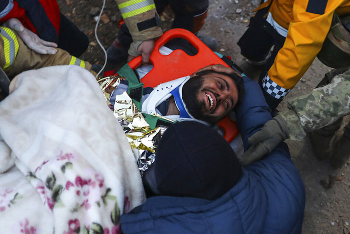 Rescatistas turcos llevan a Ergin Guzeloglan, de 36 años, a una ambulancia después de sacarlo de entre los escombros de un edificio derrumbado cinco días después de un terremoto en Hatay, en el sur de Turquía, la madrugada del sábado 11 de febrero de 2023.