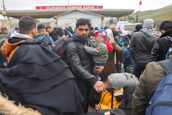 Sirios esperan para cruzar a Siria desde Turquía, en el paso fronterizo de Cilvegozu, cerca de la ciudad de Antioquía, en el sureste de Turquía, el 21 de febrero de 2023.