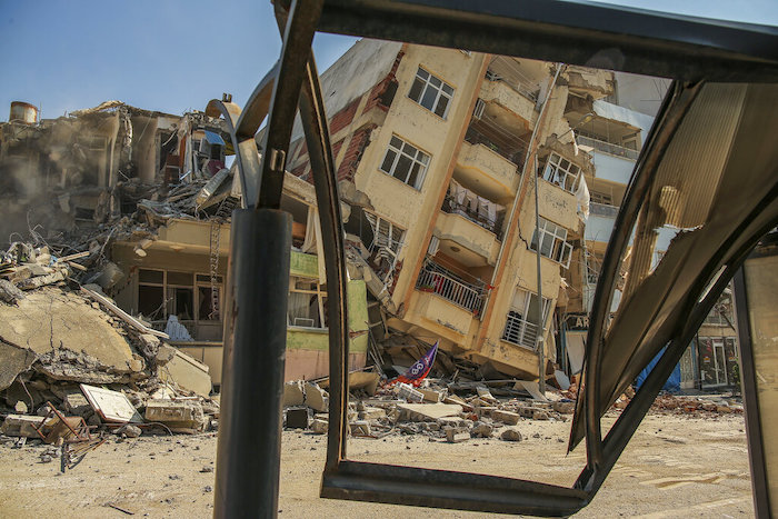 Un edifico destruido se ve inclinado sobre una casa cercana en tras una serie de sismos en Samandag, en el sur de Turquía, el miércoles 22 de febrero de 2023.