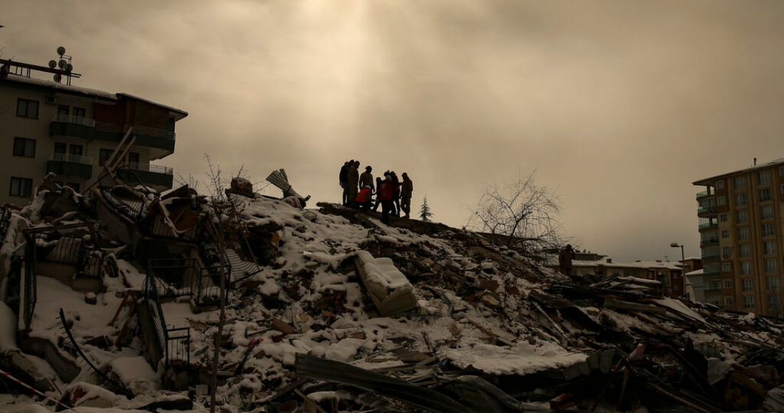 Un grupo de personas trata de llegar hasta otras atrapadas bajo los restos de un edificio derrumbado, en Malatya, Turquía, el 7 de febrero de 2023.