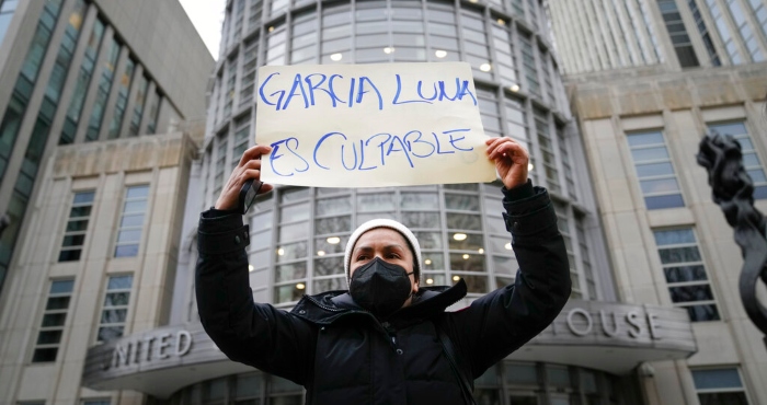 Una manifestante sostiene un letrero afuera de un tribunal federal de Nueva York, el martes 21 de febrero de 2023, momentos antes de que el exsecretario de Seguridad Pública de México, Genaro García Luna, fuera declarado culpable de aceptar sobornos para proteger a los violentos cárteles del narcotráfico a los que debía combatir.