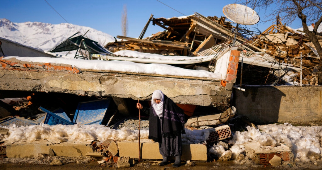 Zehra Kurukafa pasa junto a una casa destruida en la localidad de Polat, Turquía, el domingo 12 de febrero de 2023.