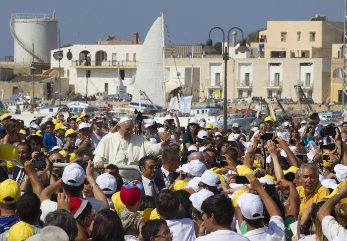 Francisco saluda a los fieles mientras avanza entre la gente durante una visita a la isla de Lampedusa, en el sur de Italia, el 8 de julio de 2013, donde denunció la "globalización de la indiferencia" que recibía a los migrantes que arriesgan sus vidas para tratar de llegar a Europa.