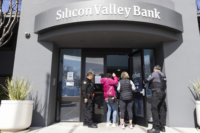 Guardias de seguridad permiten que las personas ingresen a la sede del Silicon Valley Bank en Santa Clara, California, el 13 de marzo de 2023, tres días después de declararse en quiebra.