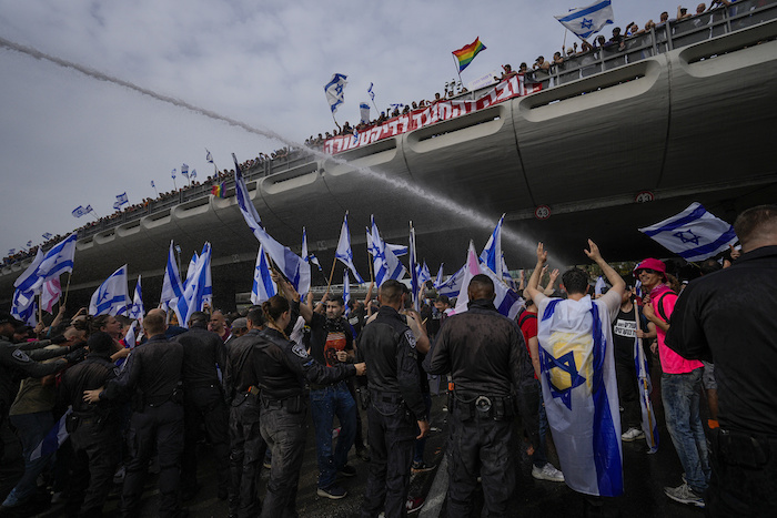 La policía israelí con cañones hidrantes dispersa una protesta contra el plan del Primer Ministro Benjamin Netanyahu de reformar el sistema judicial, en Tel Aviv, 23 de marzo de 2023.