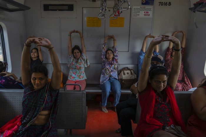 Pasajeras toman una clase de yoga en un tren como parte de los actos por el Día Internacional de la Mujer, en Mumbai, India, el 8 de marzo de 2023.